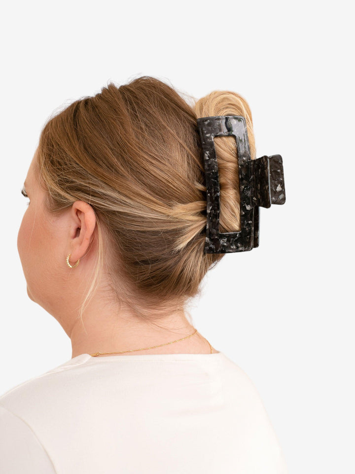 Blonde model with thick hair wearing Extra XL claw clip in black onyx.