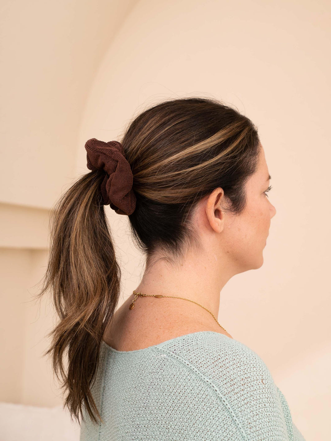 Hair wrapped with a dark brown towel scrunchie – gentle hold, frizz-free
