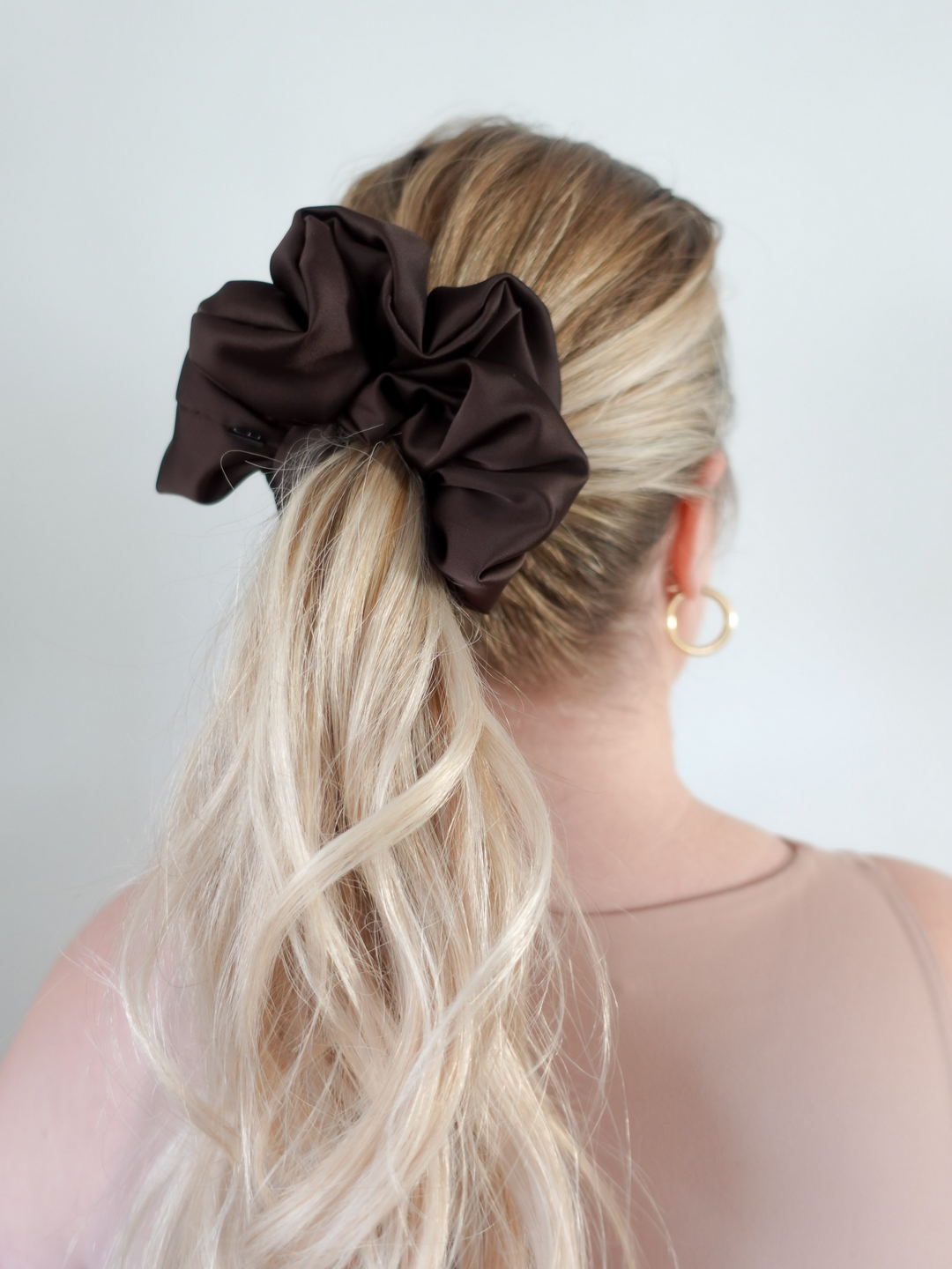 Close-up of a ponytail secured with an espresso brown satin scrunchie – frizz-free styling