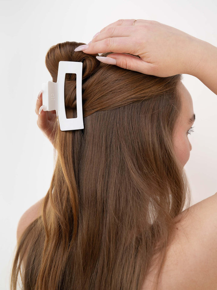 Red-haired model styling thick hair with a Next Level (Medium) claw clip in french vanilla.