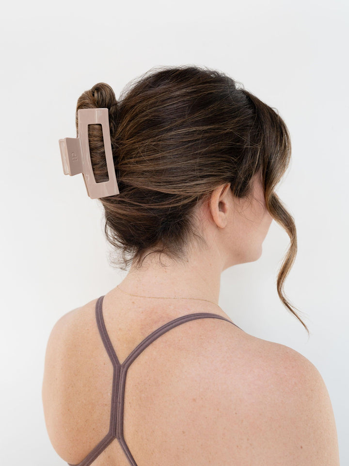Model with brown hair wearing Next Level (medium) claw clip in solid mocha for an everyday look.