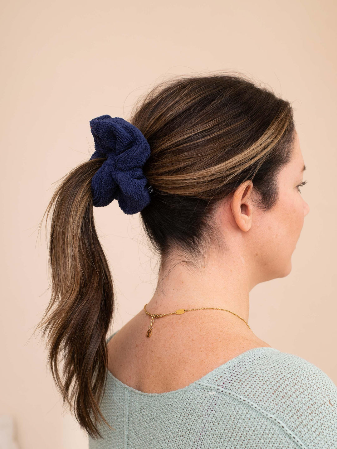 Navy towel scrunchie securing hair