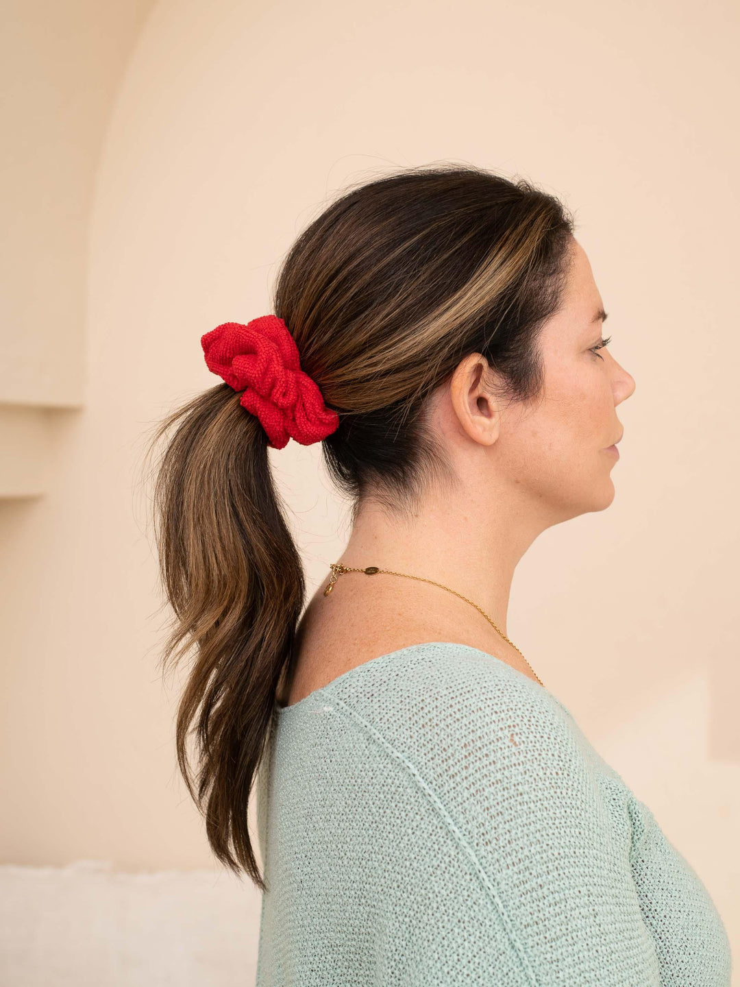 Side profile of a red microfiber towel scrunchie in brown hair - perfect for speeding up getting ready time!