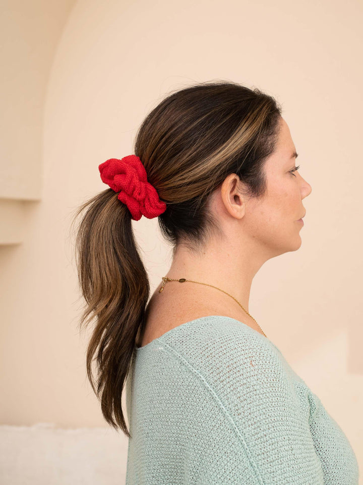 Side profile of a red microfiber towel scrunchie in brown hair - perfect for speeding up getting ready time!