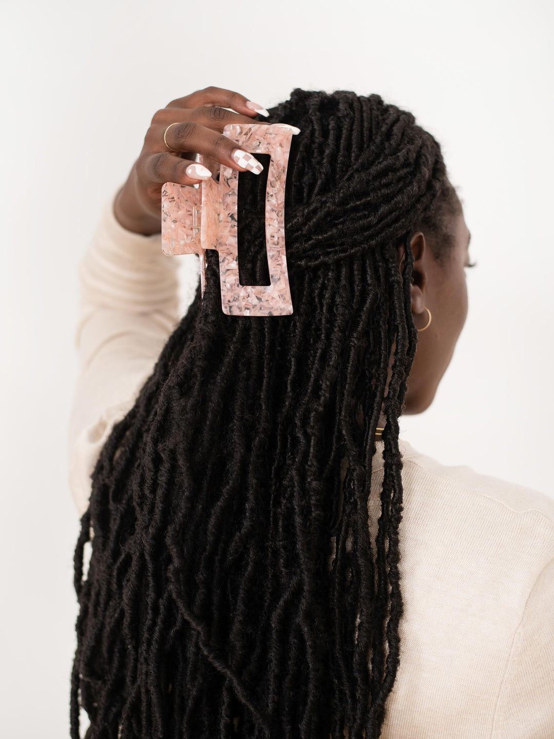 Dark-haired model styling locks with a Extra XL claw clip in Rose Quartz.