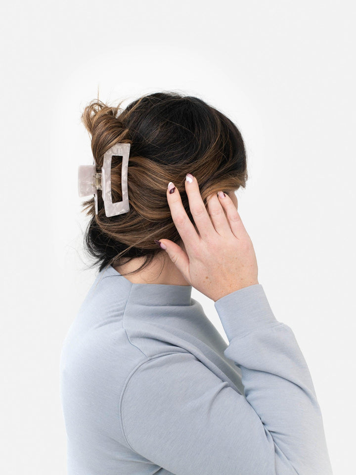 Model with brown hair wearing Next Level claw clip in white pearl for an everyday look.