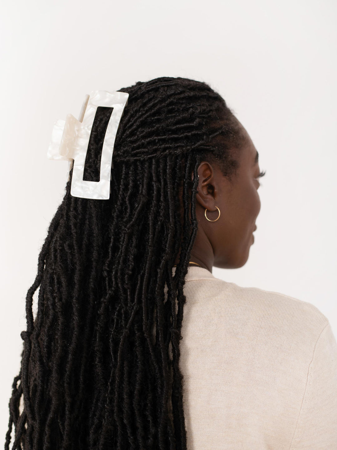 Side profile of model with locks wearing Extra XL claw clip in white pearl.