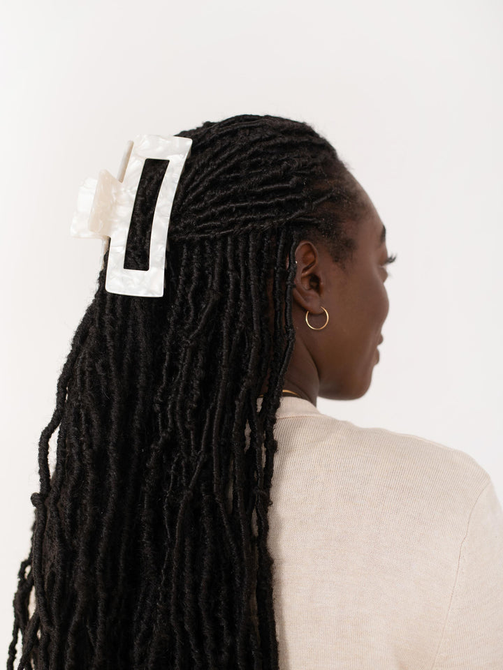 Side profile of model with locks wearing Extra XL claw clip in white pearl.